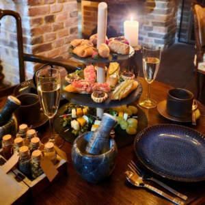 Alchemist's Afternoon Tea in Krakow, a candlelit table with Prosecco and potion bottles